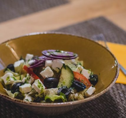 A delicious Greek salad featuring feta cheese, olives, and fresh vegetables in a rustic bowl.