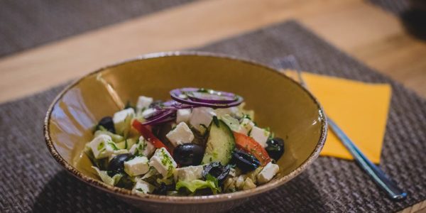 A delicious Greek salad featuring feta cheese, olives, and fresh vegetables in a rustic bowl.